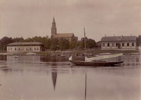 Vanhassa kuvassa alus seilaa kaupungin rannan lähellä.