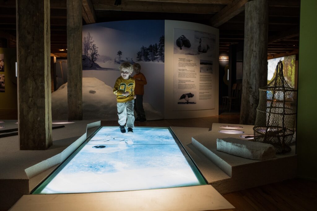 lapsi kulkee museonäyttelyn jäätietä pitkin