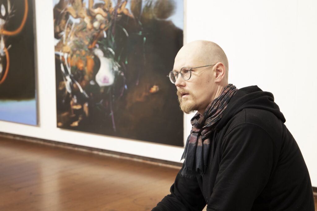 Mies taidenäyttelyssä.