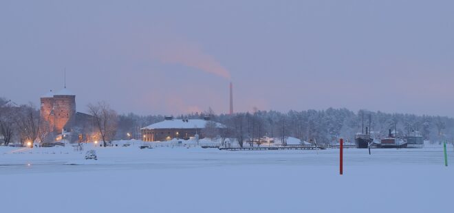 Riihisaaren museorakennus talvisessa maisemassa sekä museolaivat ja Olavinlinna.