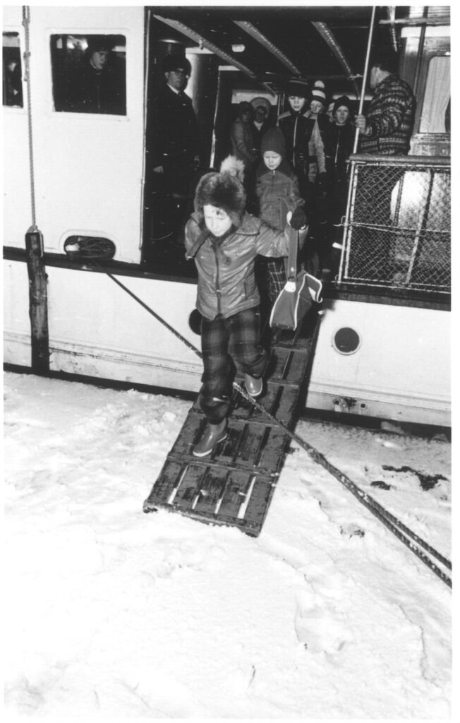 Lapsi laskeutuu alas vanhan laivan laskusiltaa, joka päättyy järven jäälle.