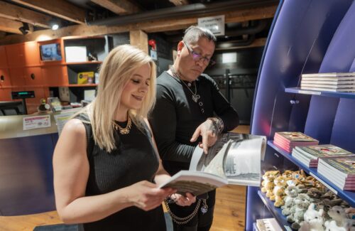 Pariskunta katselee museokaupan kirjoja. Edessä hyllyllä myös pehmoleluja.