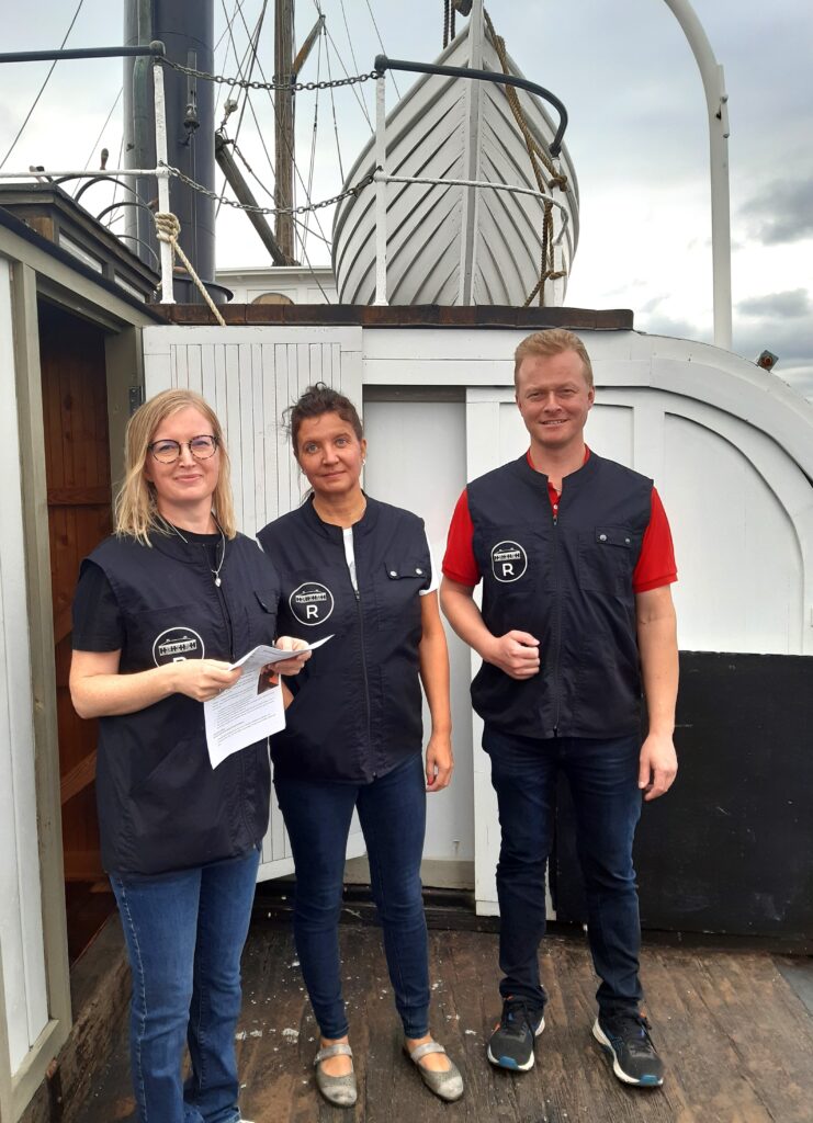 Ihmisiä seisoo vanhan laivan kannella.