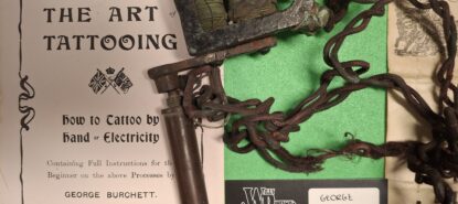 Ruosteenvärisiä naruja mutkalla ja samanvärisiä metalliosia. Taustalla tekstiä englanniksi.)