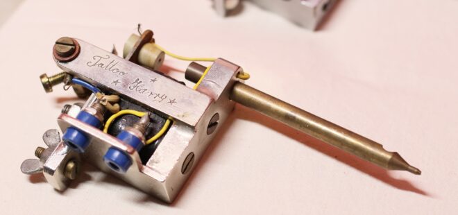 Yksityiskohtainen pieni metalliesine, jossa yksi osa muistuttaa mustekynää.