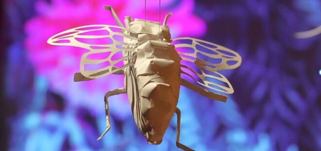 Paperihyönteinen violetilla taustalla