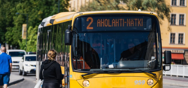 Nuori nainen nousemassa paikallisbussiin.