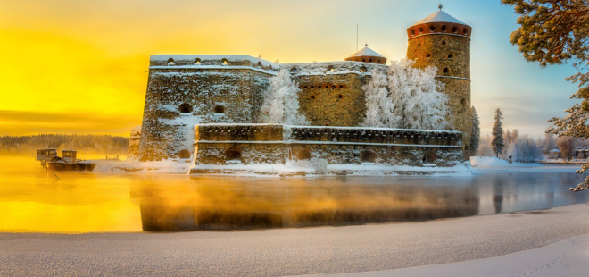 Olavinlinna talvimaisemassa auringonpaisteessa.